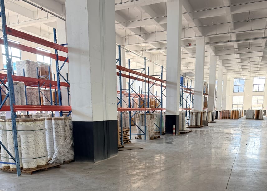 Warehouse racks holding PET rolls ready for selection.